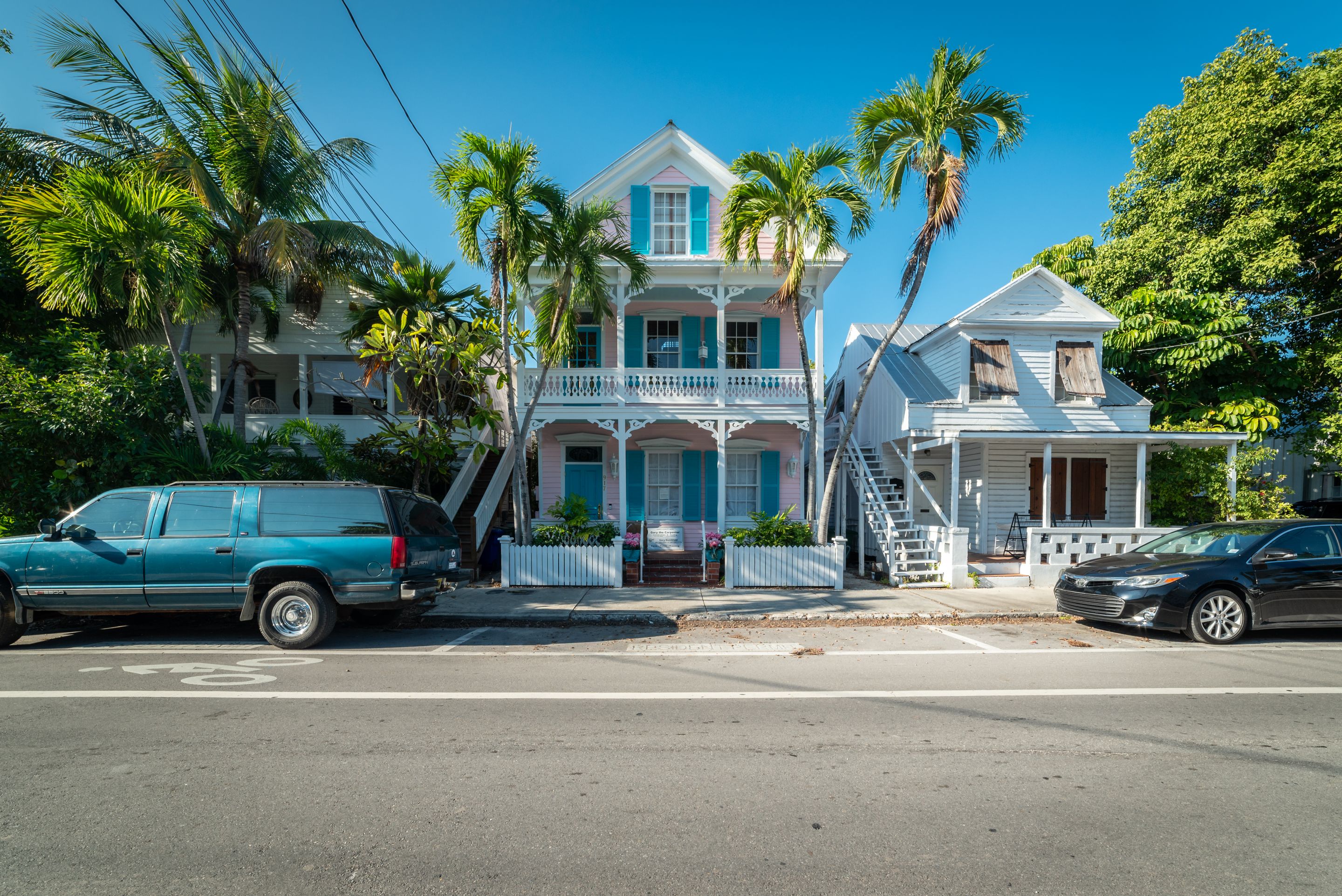 Pastel clapboard cottages with deep porches beneath coconut palms
