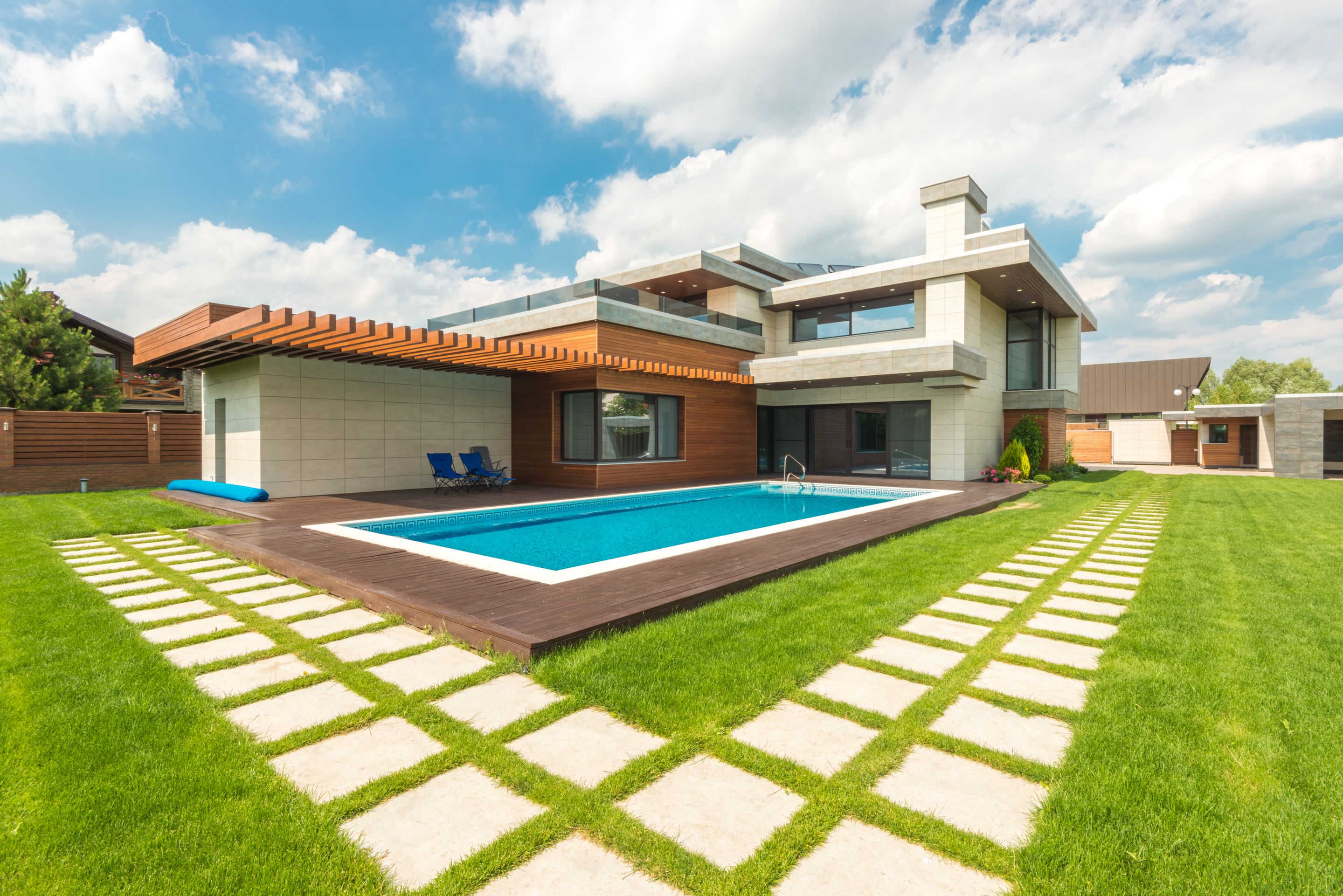 A suburban house with a swimming pool and a wide lawn