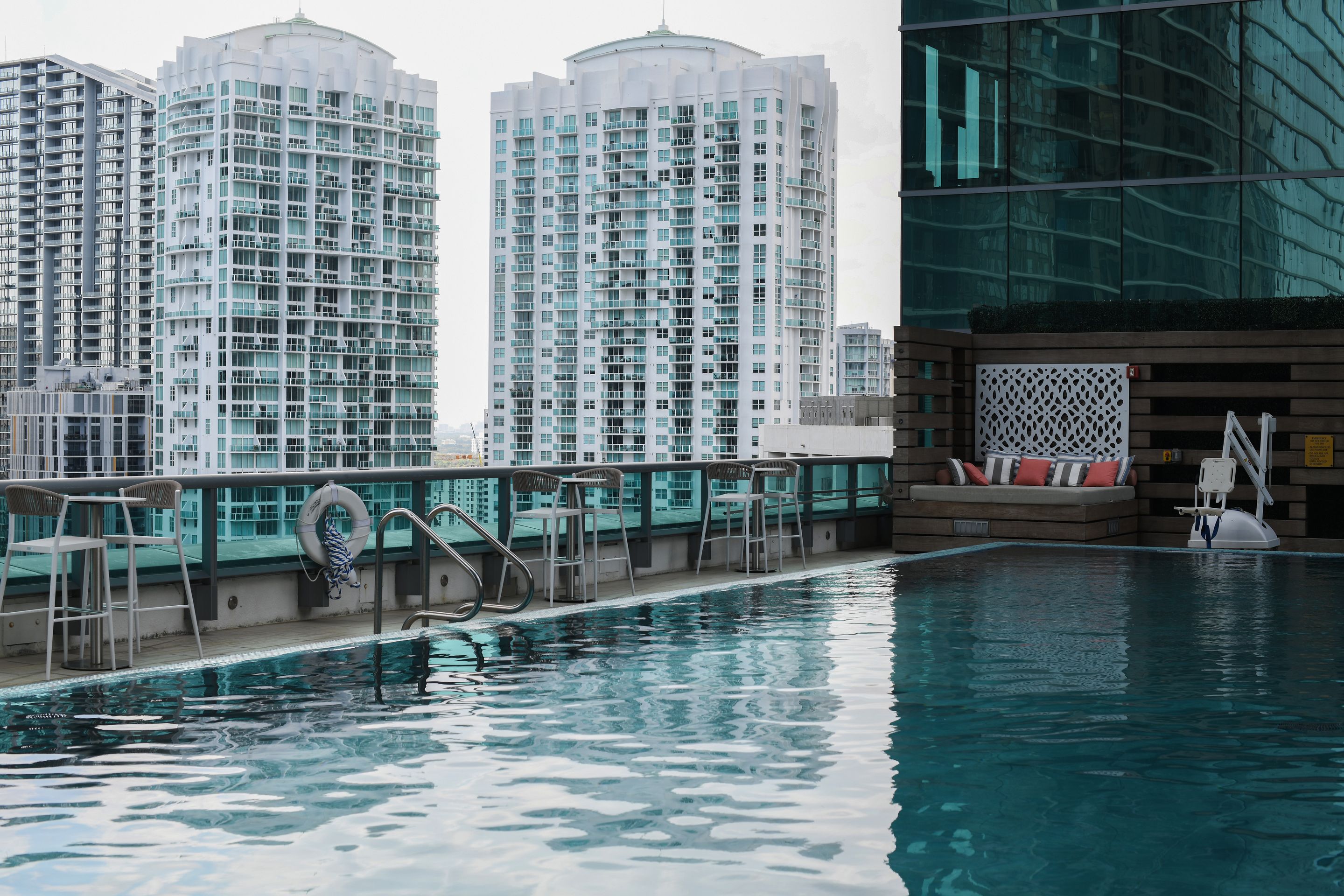 A rooftop swimming pool against a backdrop of condominium towers